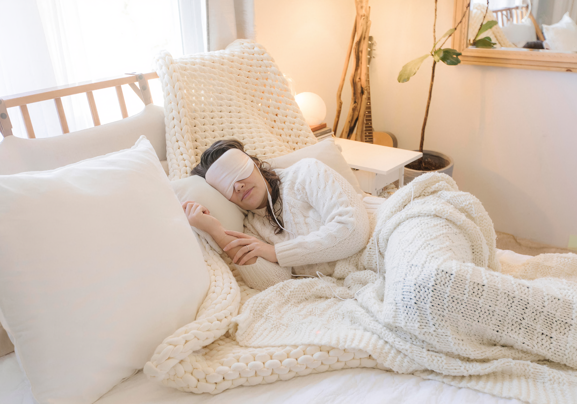 Model lyying down wearing the comfylids Silk heat mask